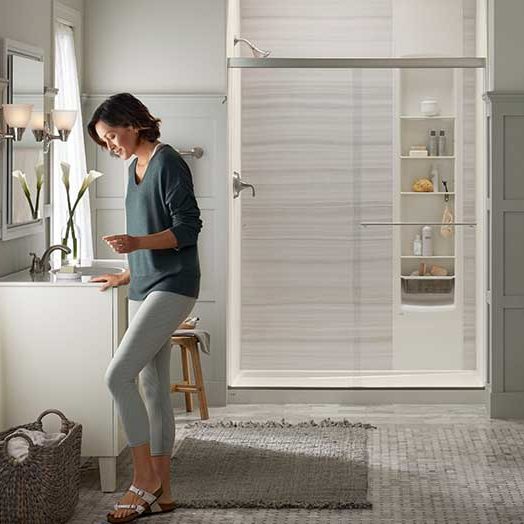 woman getting undressed to take a Kohler shower