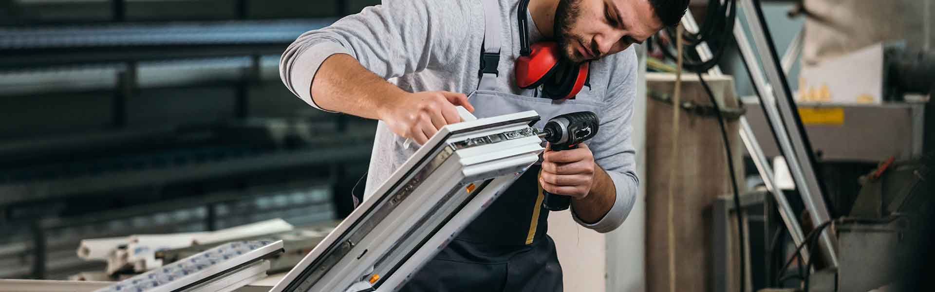 a man working on a window in a window manufacturing facility