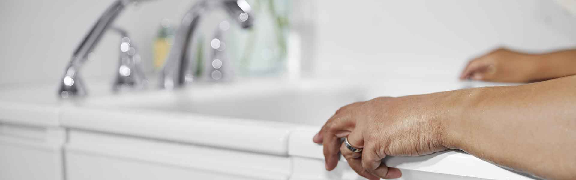 snapshot of woman's arms holding side of walk-in tub while she is in it