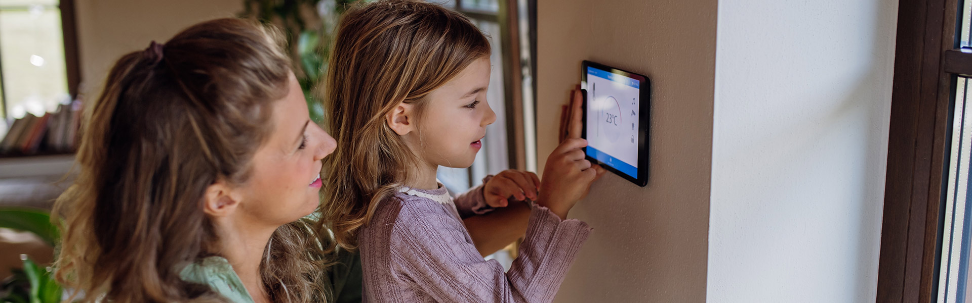 A kid adjusting the digital thermostat